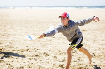 teen boy playing on a beach 