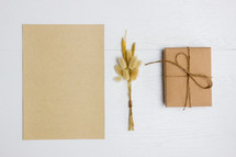 blank paper, fuzzy grasses, and wrapped gift 
