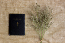 Holy Bible and dried flowers on linen 