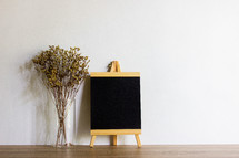 vase of tall grasses and blank chalkboard 