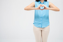 a woman making a heart with her hands 