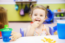 toddler eating a snack at preschool 