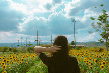 a woman standing in a field of sunflowers 