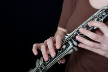 Hands holding an oboe.