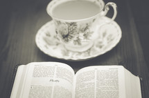 tea cup, saucer, and open Bible 