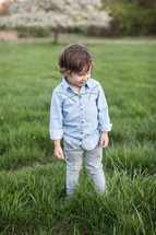 boy child standing in green grass 