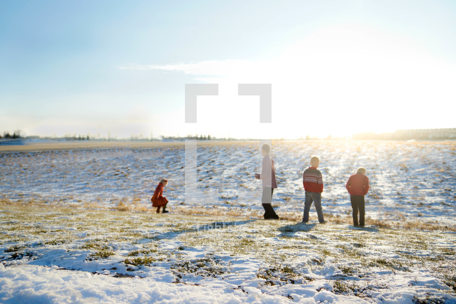 kids playing in snow in a field 