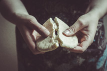 A woman breaking bread.