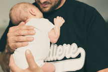 a father holding a newborn baby 