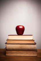 A red apple on a stack of books.