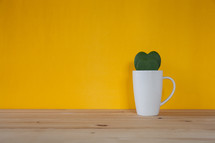 heart shaped leaves in a white mug 