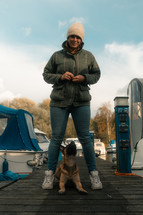 Cute dog and owner in a marina setting, dog sitting, woman with her dog, friendship, friends, cute pet photo