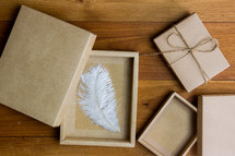 wrapped brown paper gift box and feather