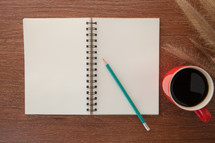 pencil and sketchpad with coffee mug