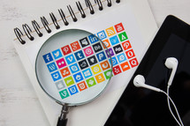 magnifying glass over social media app icons 