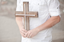 man holding a cross in front of his chest