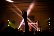 silhouette of a raised hands at a concert 