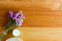 bouquet of purple flowers and candle on a wood background 