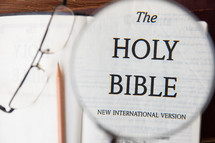 magnifying glass over Bible title page 