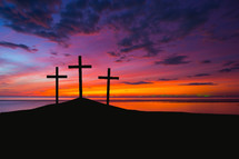 silhouette of three crosses on a hill at sunrise 