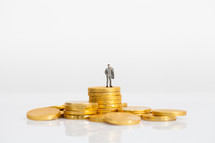 a miniature figurine standing on gold coins 