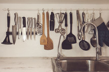 utensils hanging in a kitchen over a sink 