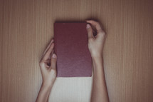 hands opening a Bible 