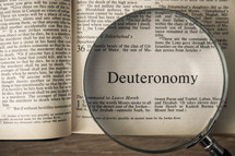 magnifying glass over Bible - Deuteronomy 