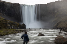 a woman watching a waterfall in Iceland 