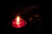 red glass, candle, flickering flame 