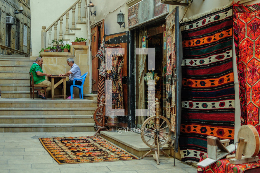 store front with rugs hanging outside. Handmade crafts and carpets in Baku, Azerbaijan.