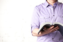 man holding an open Bible