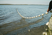 Man pulling in a fishing net.