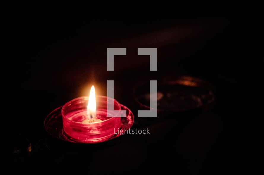 red glass, candle, flickering flame 