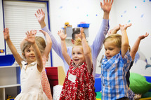 children with hands raised