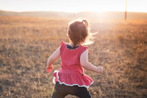 toddler girl running in a field  