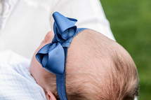 a newborn girl with a bow on her head 