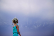 a young girl looking up at the sky 