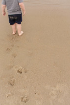 toddler boy bare foot in the sand 