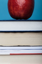 A red apple on a stack of books.