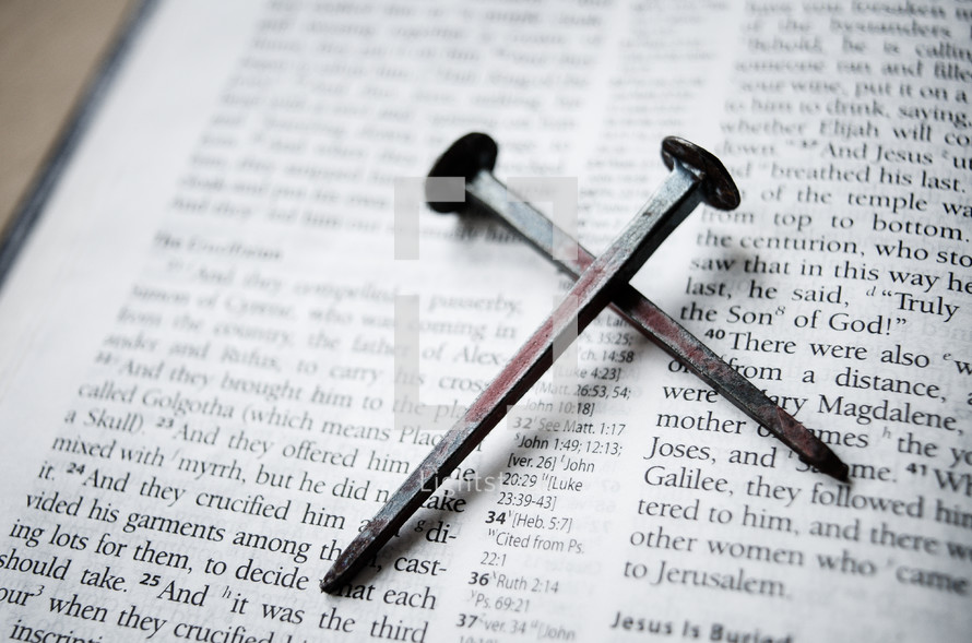 cross of nails on the pages of a Bible 