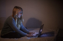 young woman on her bed on the internet 