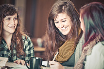 young women smiling as they discuss scripture during a Bible study