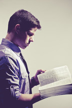 man reading a Bible against a white background