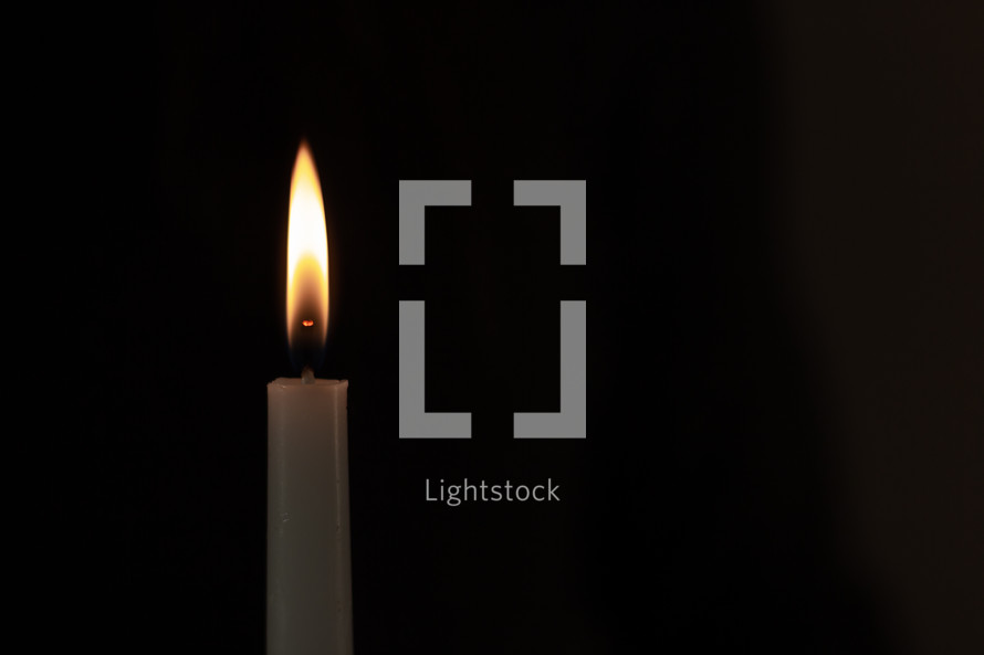white candle on a black background 