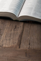 An open book on a wooden surface.