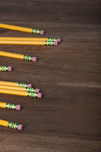 Pencils laying on a wooden surface.