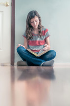 Girl sitting on the floor reading her bible