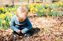 a toddler playing in leaves in spring 