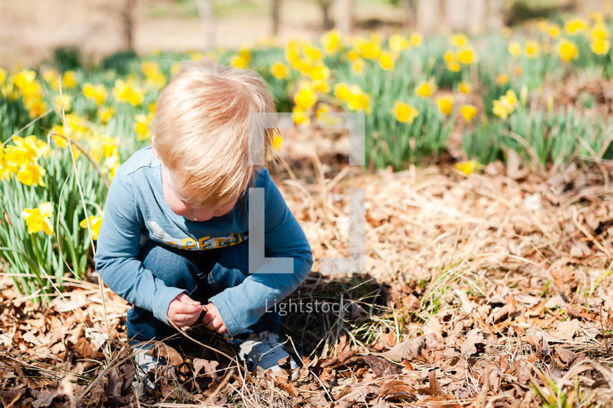 a toddler playing in leaves in spring 